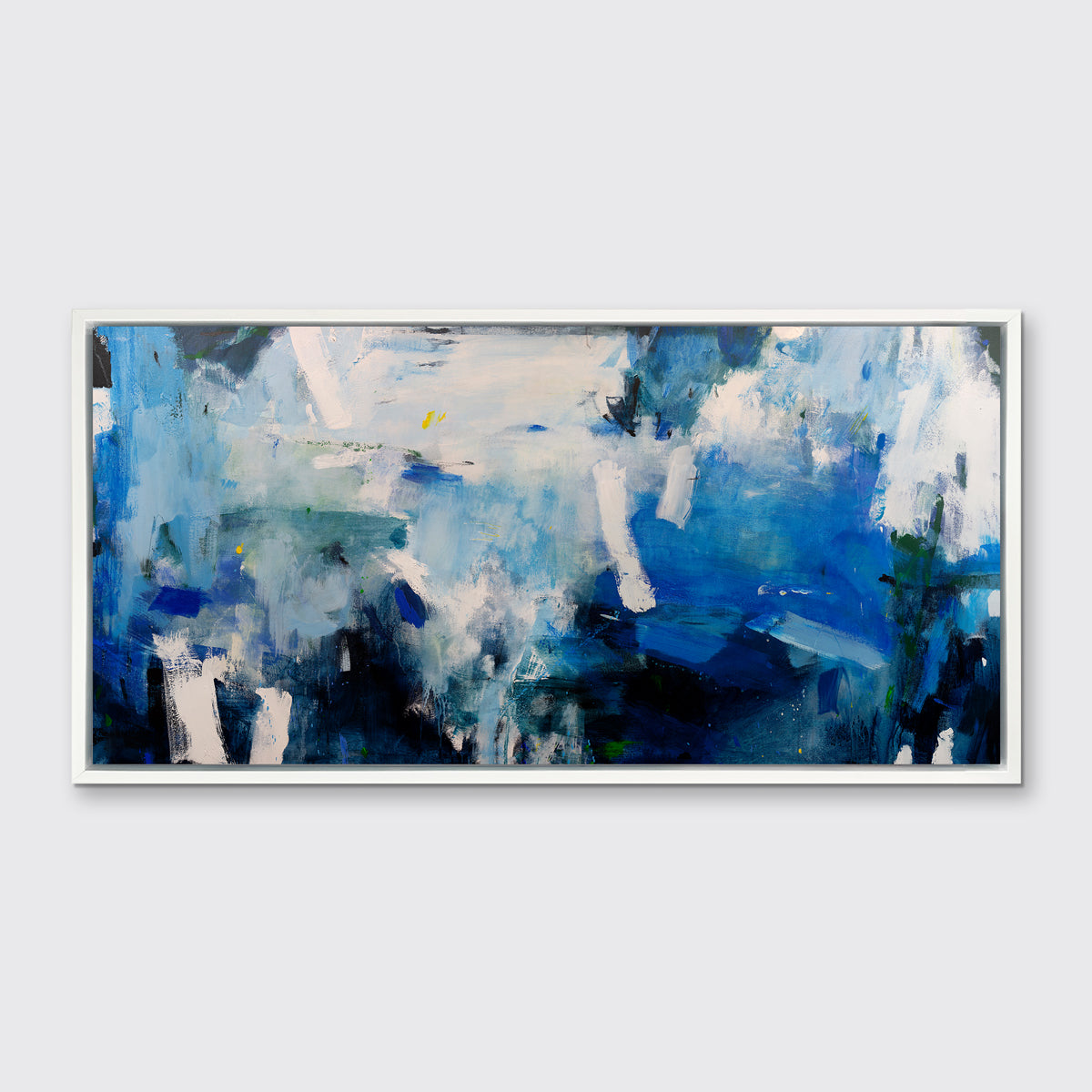 A blue, white and black abstract print in a white floater frame hangs on a white wall.