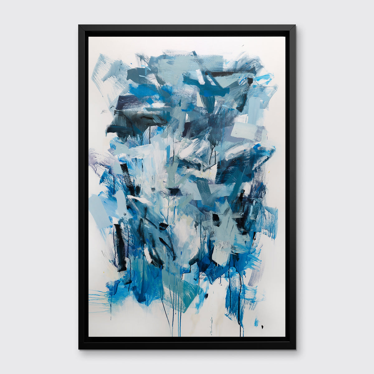 A blue, teal and white abstract print in a black floater frame hangs on a white wall.