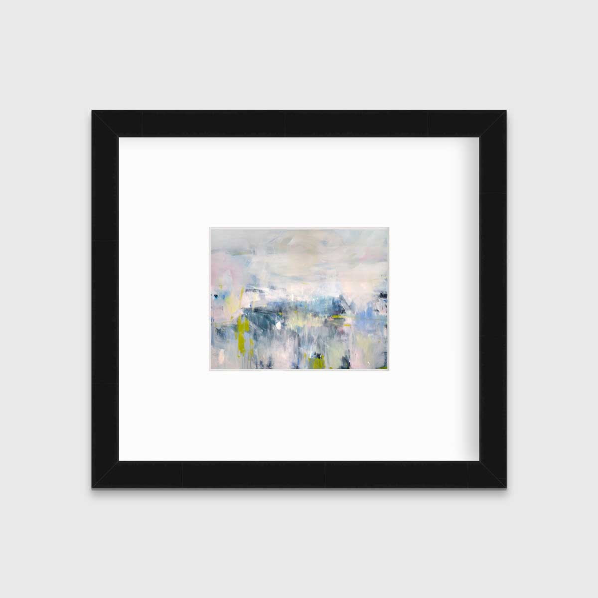 A pink and blue abstract print in a black frame with a mat hangs on a white wall.