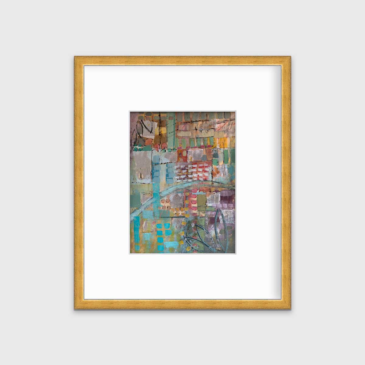 A multicolored abstract print in a gold frame with a mat hangs on a white wall.