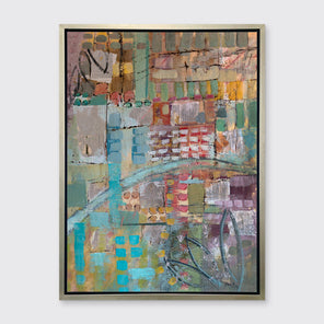 An abstract print, with green, blue, and yellow geometric and organic shapes, framed in a silver floater frame on a grey wall.