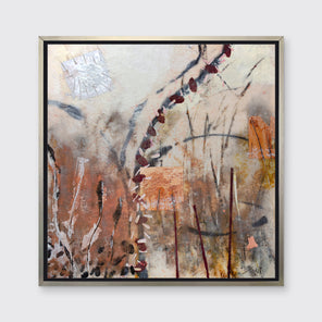 A beige, copper, gold and silver abstract print in a silver floater frame hangs on a white wall.