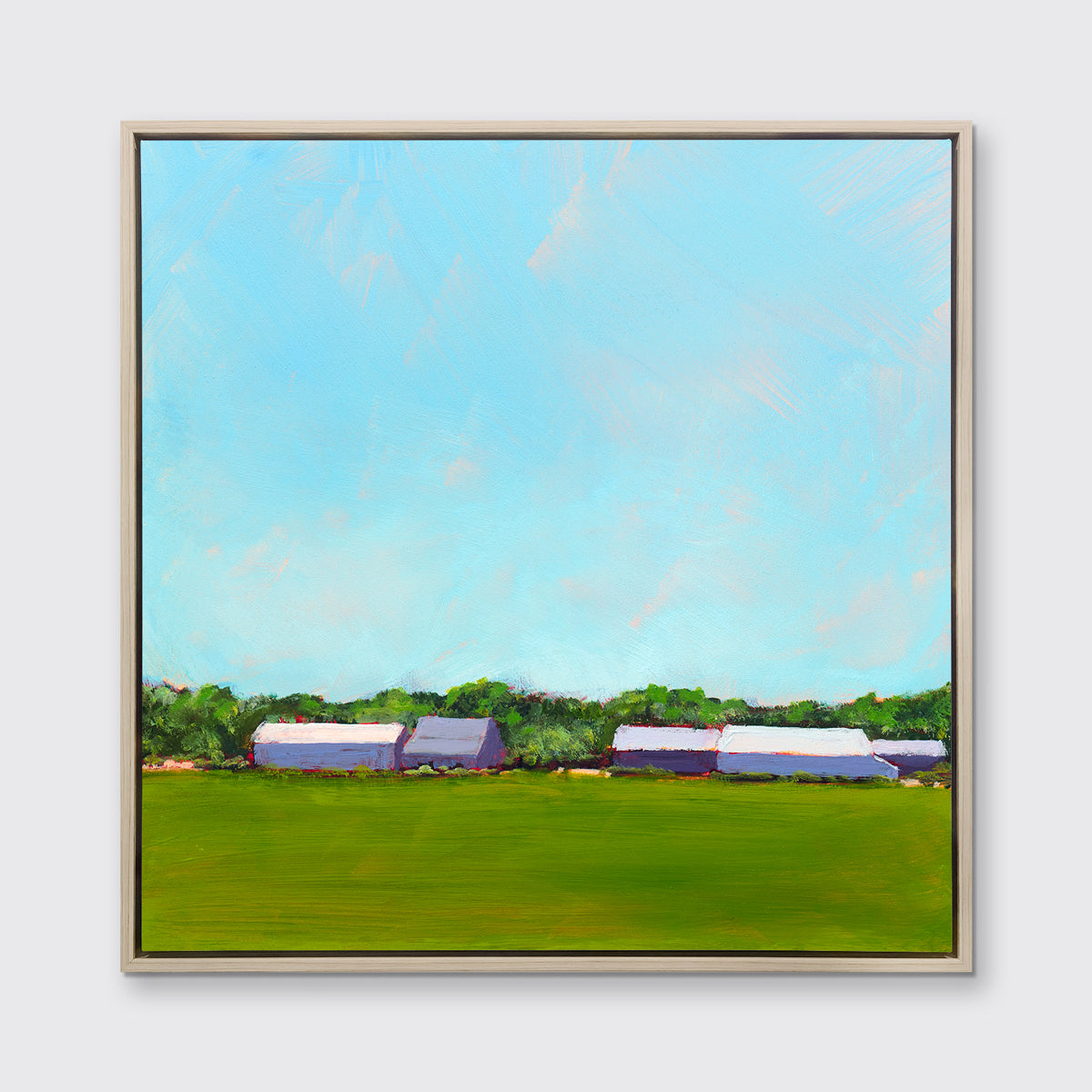 A blue, green, lavender and white landscape print in a white oak wood floater frame hangs on a white wall.