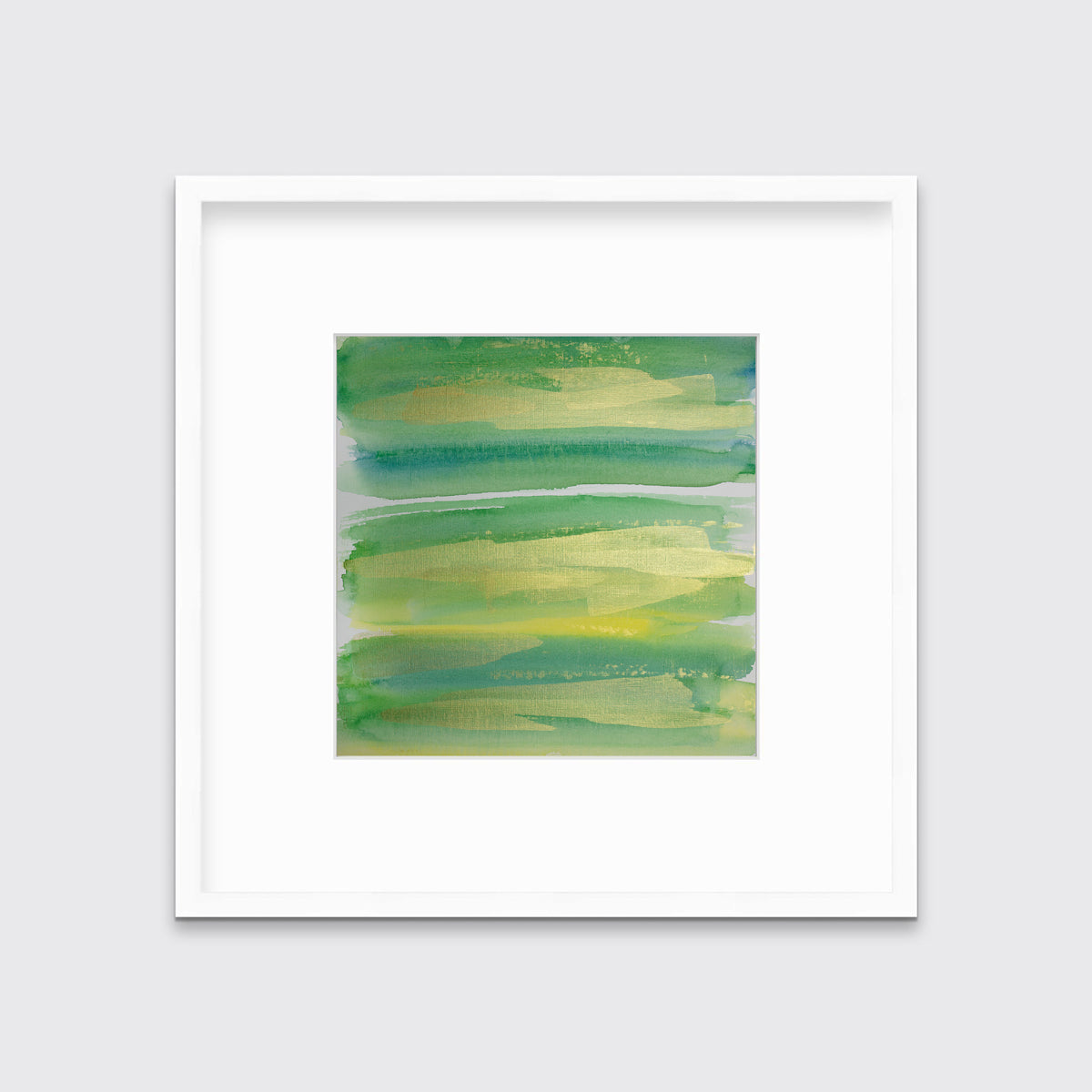 A green, blue and gold abstract print in a white frame with a mat hangs on a white wall.