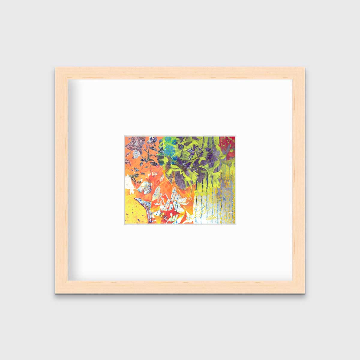 A multicolored abstract print in a natural wood frame with a mat hangs on a white wall.