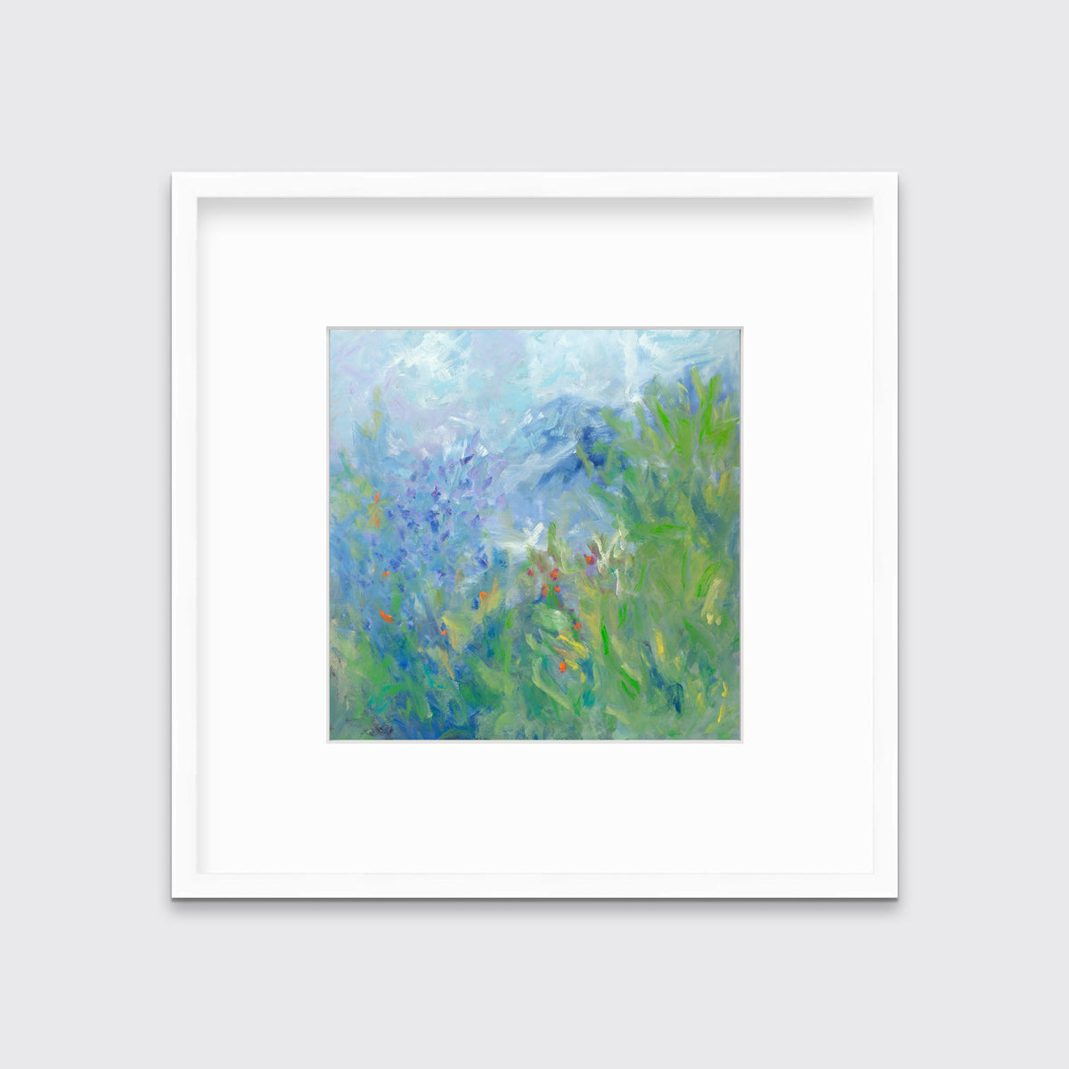 A blue, green, yellow and white abstract floral print in a white frame with a mat hangs on a white wall.