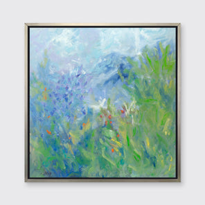 A blue, green, yellow and white abstract floral print in a silver floater frame hangs on a white wall.