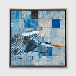 A blue abstract print of a blue heron in flight in a silver floater frame hangs on a white wall.