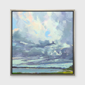 A blue, white and green abstract landscape print in a silver floater frame hangs on a white wall.