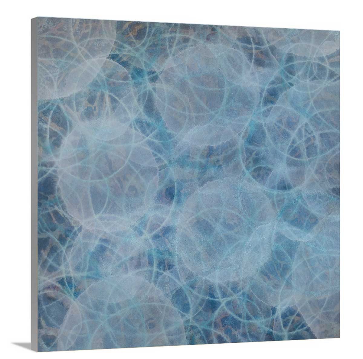 Layers of overlapping circles in hues of blue and white staged on a side angle of a canvas.