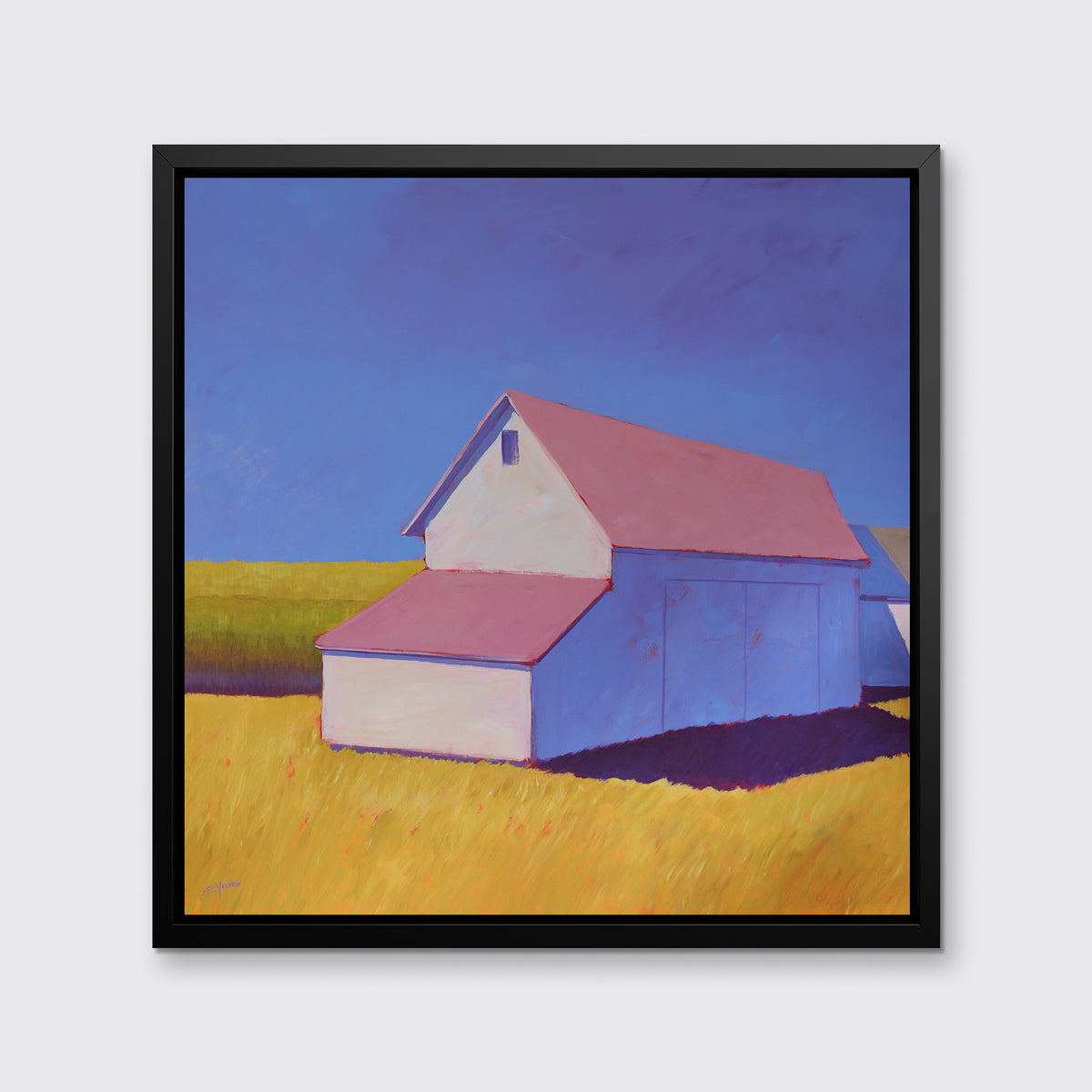 A white barn with a pink roof and yellow grass print in a black floater frame hangs on a white wall.