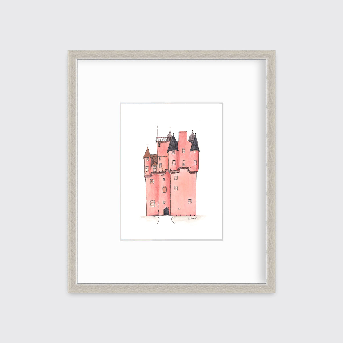 A pink and grey castle print in a silver frame with a mat hangs on a white wall.