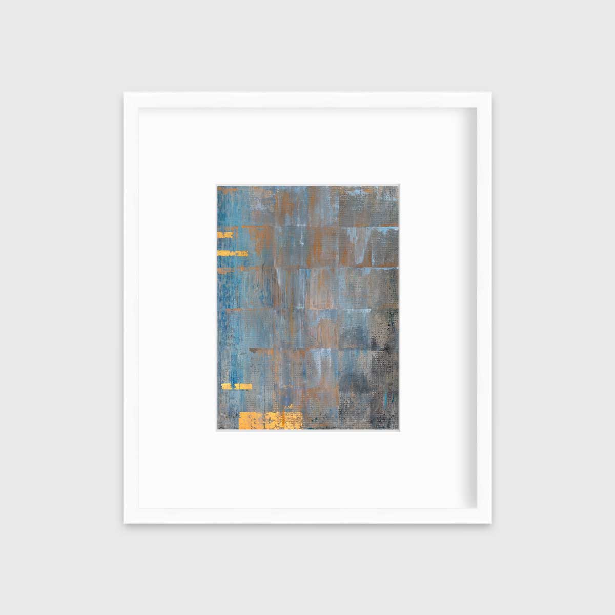 A blue, grey and gold abstract geometric print in a white frame with a mat hangs on a white wall.