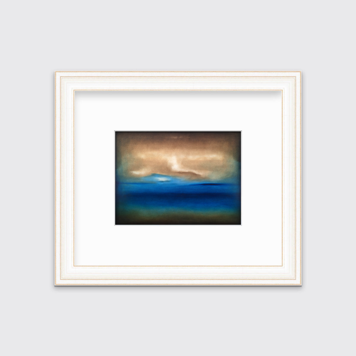 A dark brown, blue, white and teal abstract landscape print in a white and gold frame with a mat hangs on a white wall.