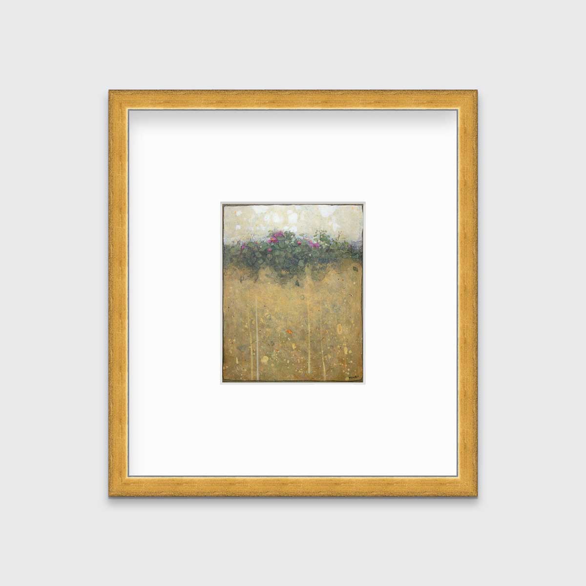 A dark yellow, green and beige abstract landscape print in a gold frame with a mat hangs on a white wall.