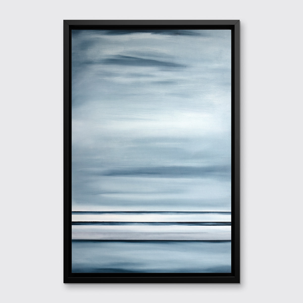 Abstract print features blue-grey horizontal lines and blocks of blended color in a black floater frame hanging on a white wall.