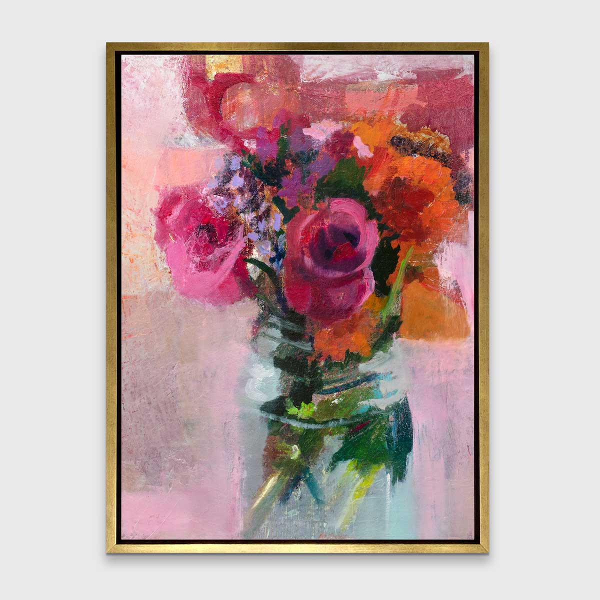 A pink, orange and green abstract floral print in a gold floater frame hangs on a white wall.