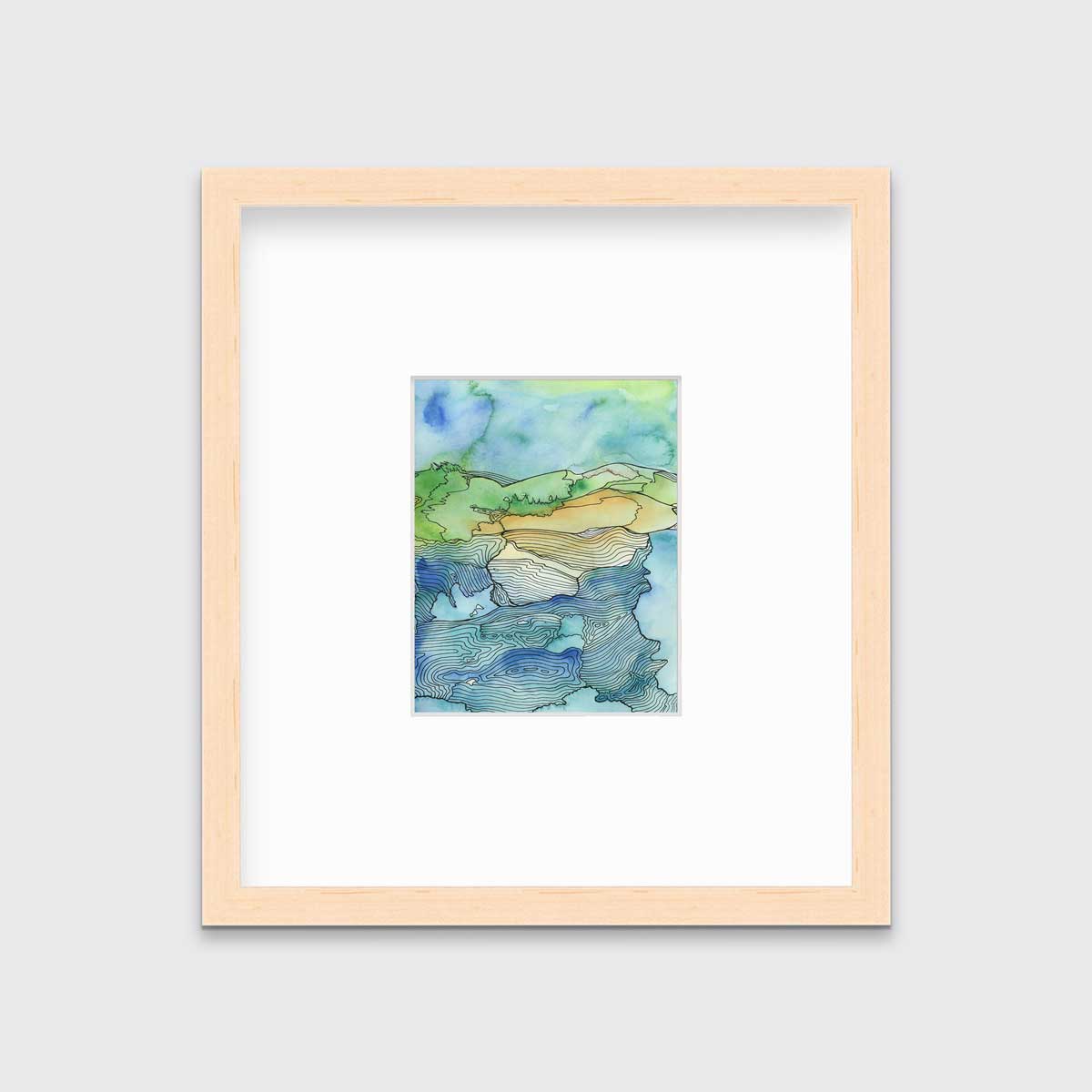 A blue and green landscape illustration in a natural wood frame with a mat hangs on a grey wall.