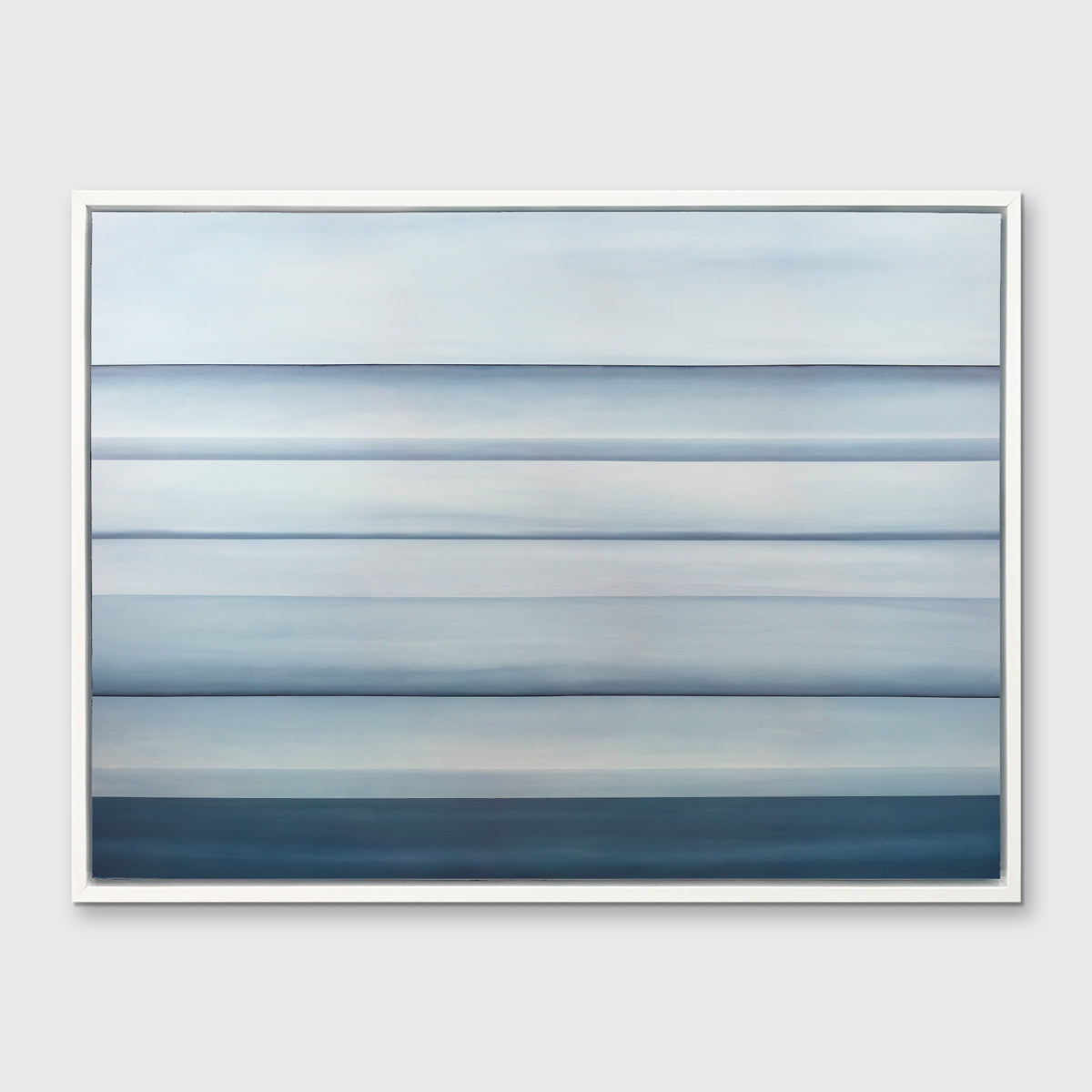 A tonal blue abstract landscape print in a white floater frame hangs on a white wall.