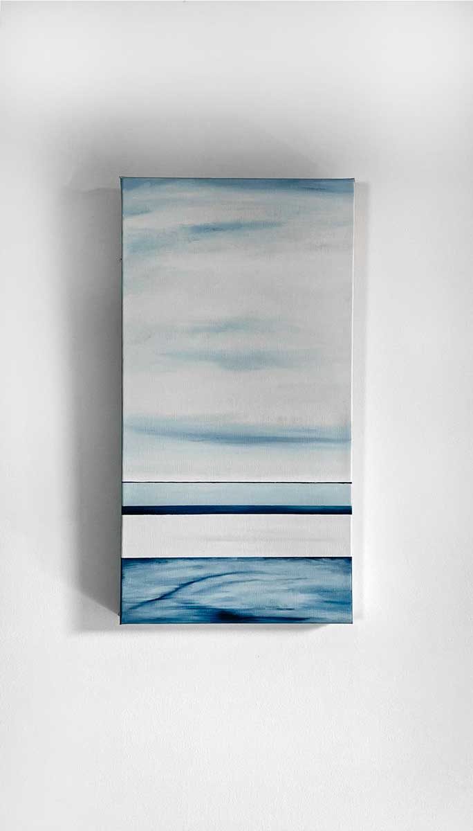 Blue and white geometric abstract painting hangs on a white wall.