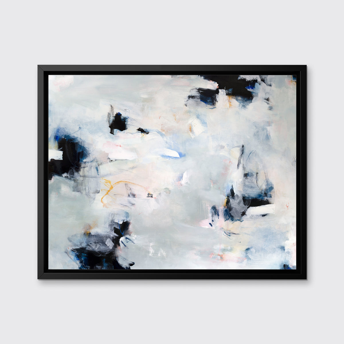 A white, black and grey abstract print in a black floater frame hangs on a white wall.