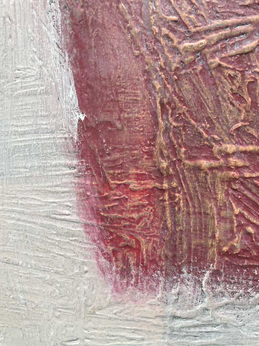 A close up detail of the texture in the red and white paint with orange accents.