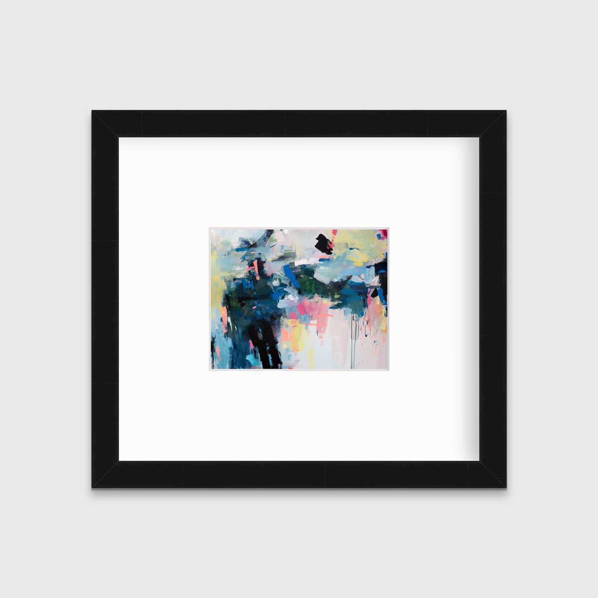 A colorful abstract print by Kelly Rossetti in a black frame with a mat hangs on a white wall.