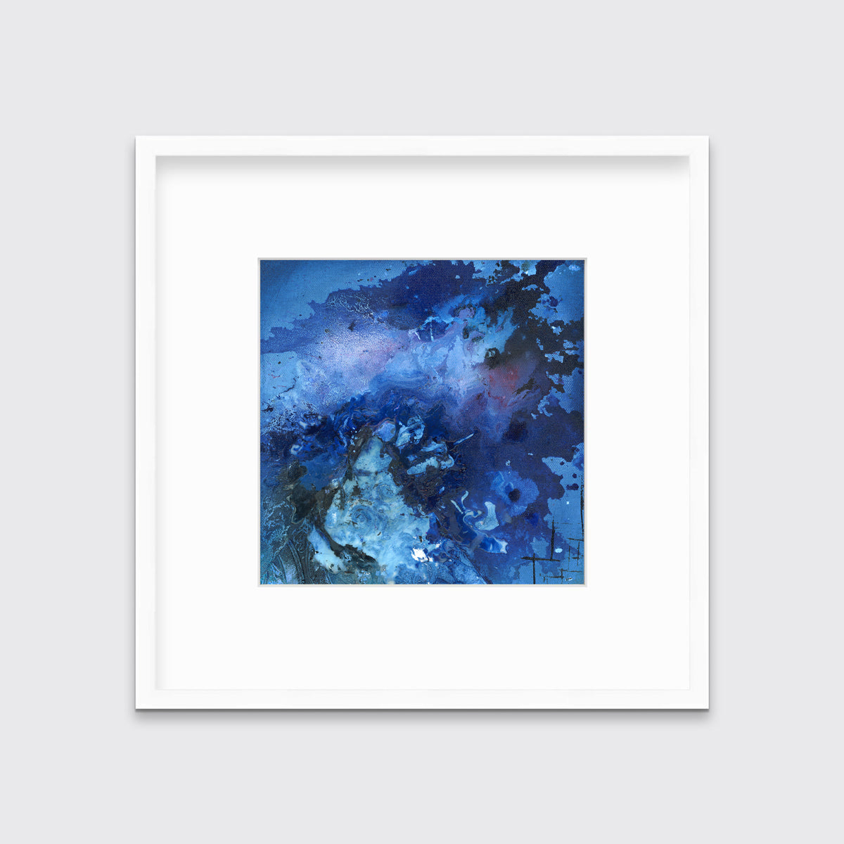 A blue and black abstract print in a white frame with a mat hangs on a white wall.