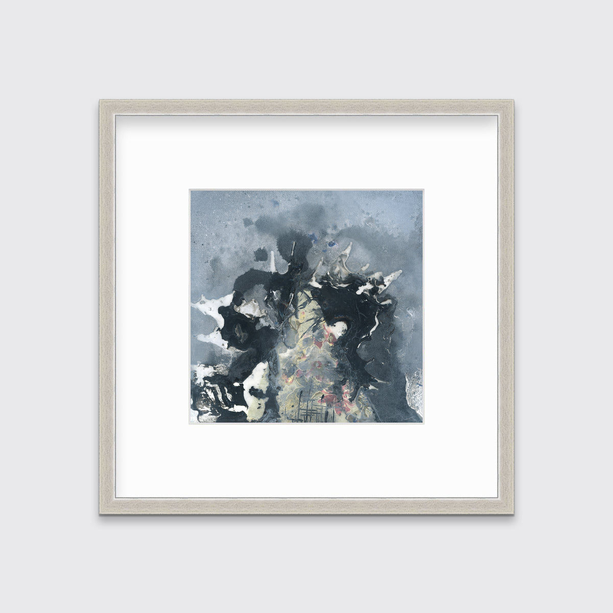 A grey, black, white and light yellow abstract print in a silver frame with a mat hangs on a white wall.