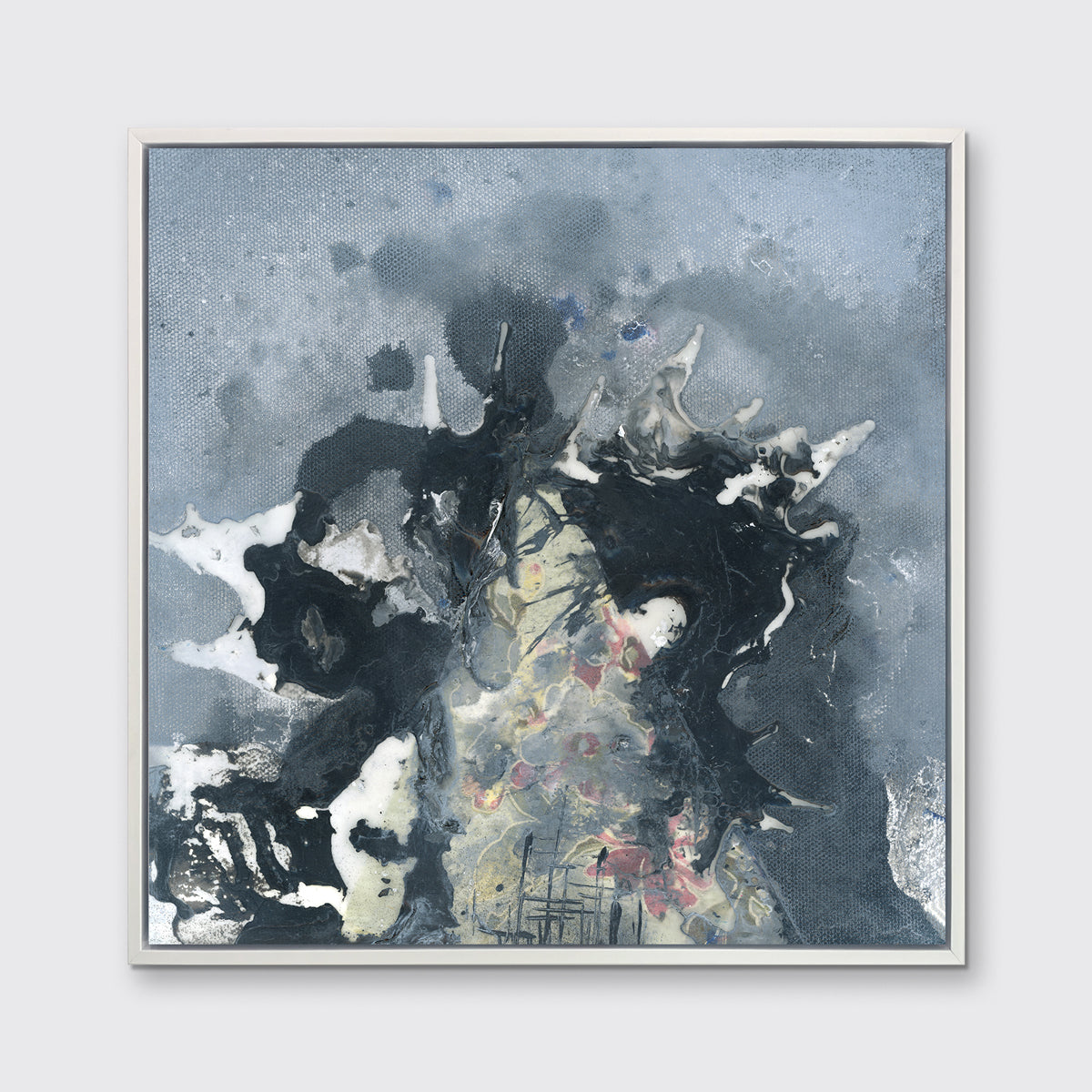 A grey, black, white and light yellow abstract print in a white floater frame hangs on a white wall.