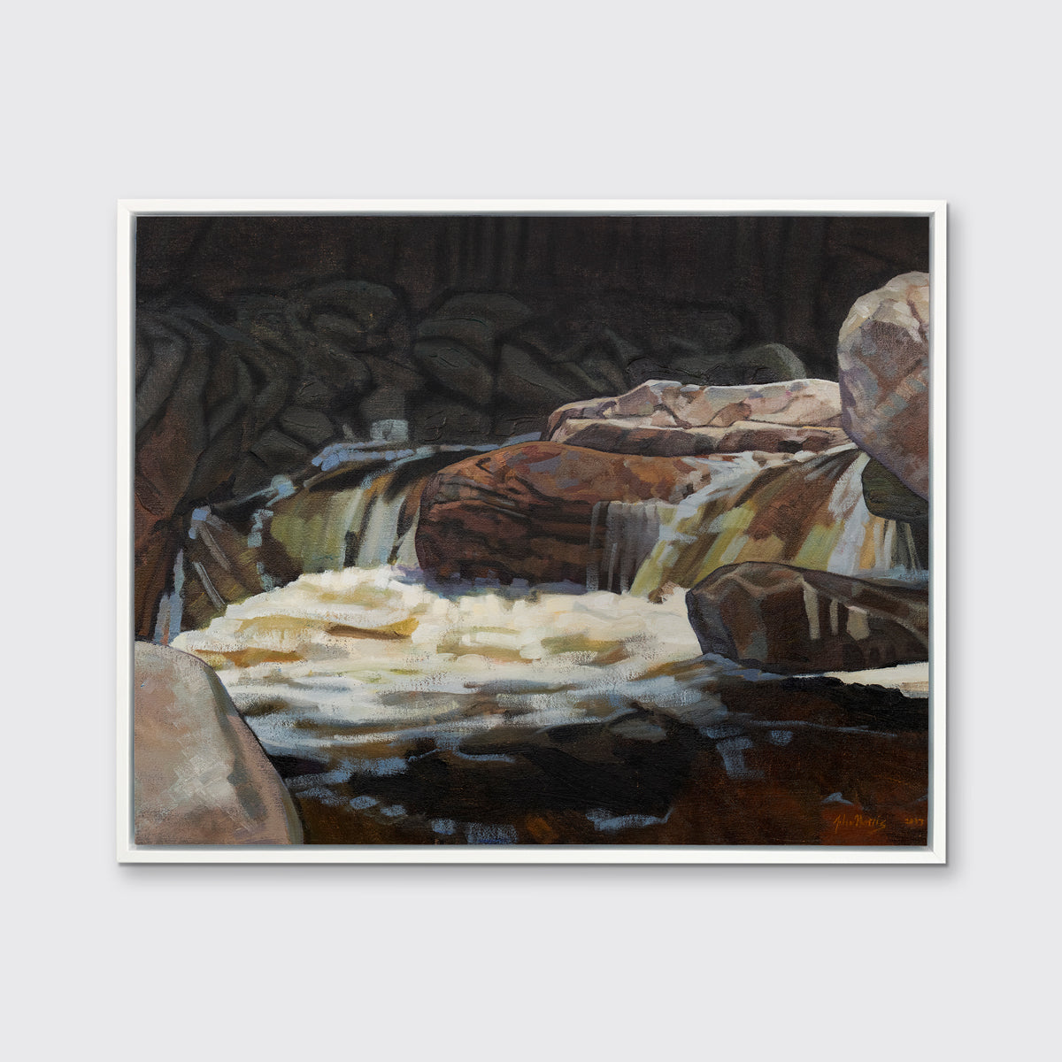A brown, black and white abstract river landscape print in a white floater frame hangs on a white wall.