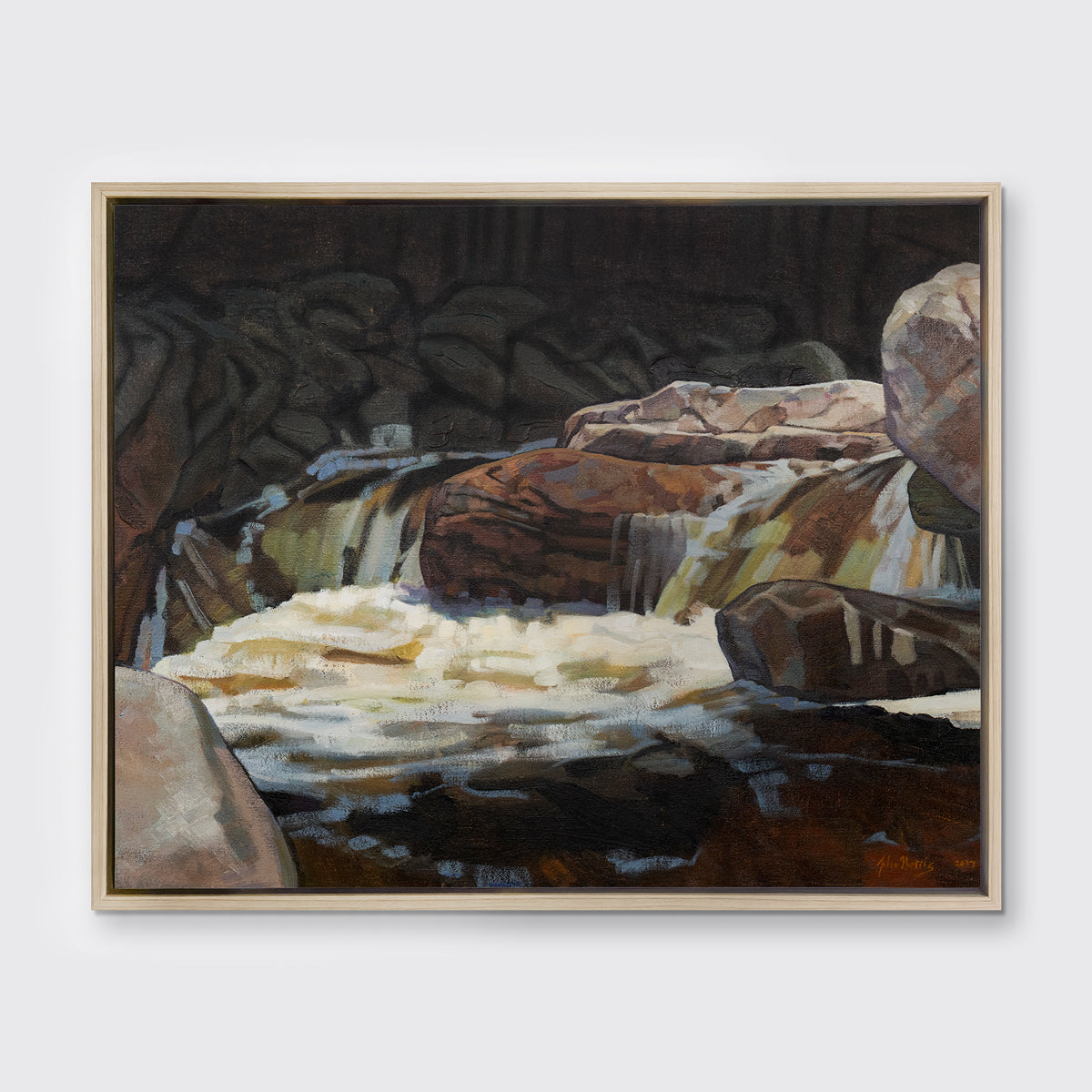 A brown, black and white abstract river landscape print in a white oak wood floater frame hangs on a white wall.