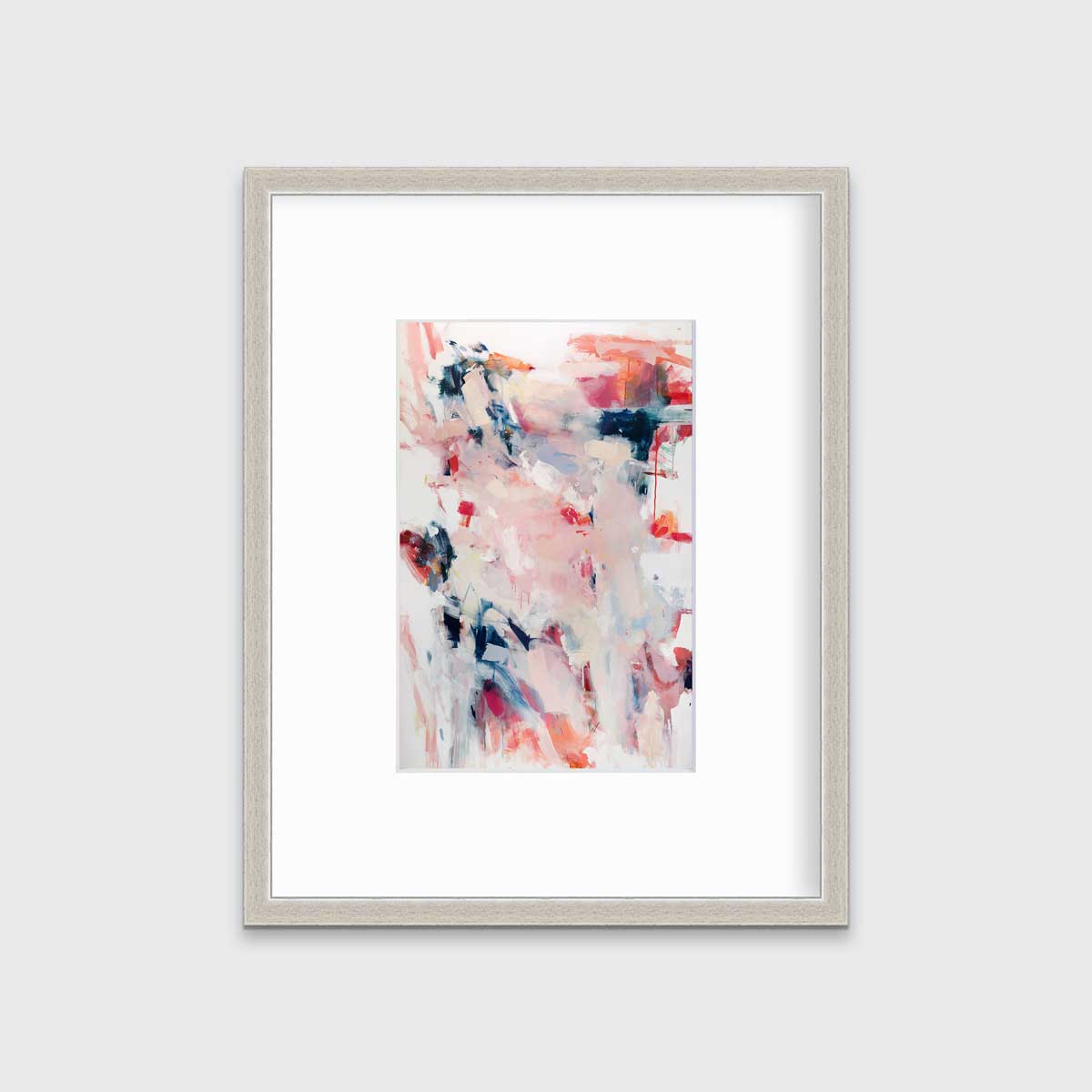 A pink and white abstract print by Kelly Rossetti in a silver frame with a mat hangs on a white wall.