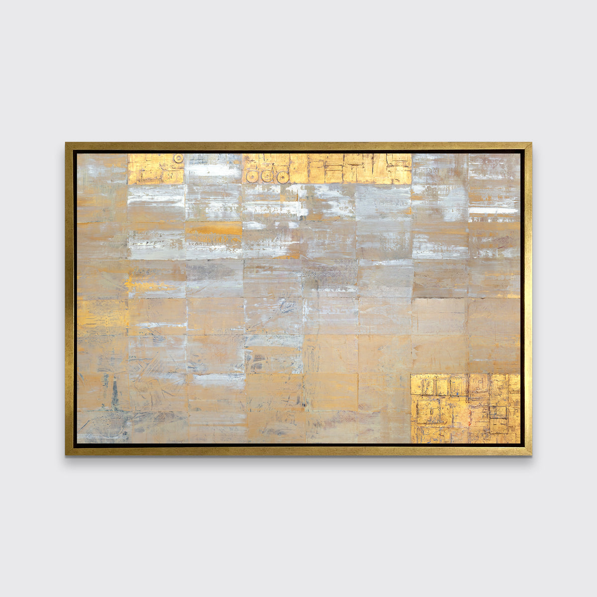 A grey, silver and gold abstract geometric print in a gold floater frame hangs on a white wall.