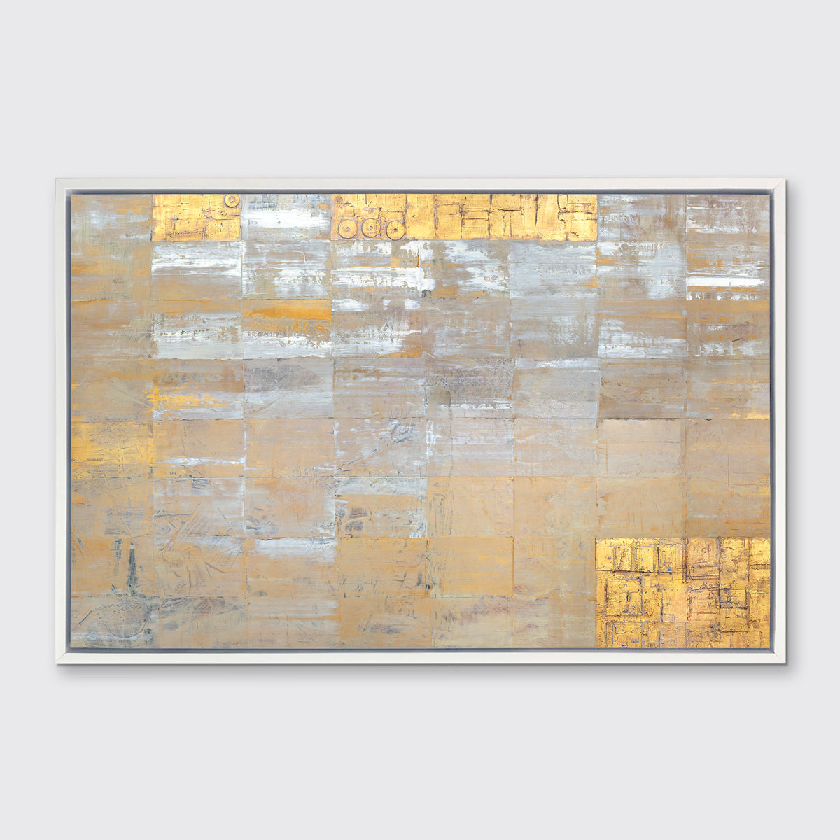 A grey, silver and gold abstract geometric print in a white floater frame hangs on a white wall.