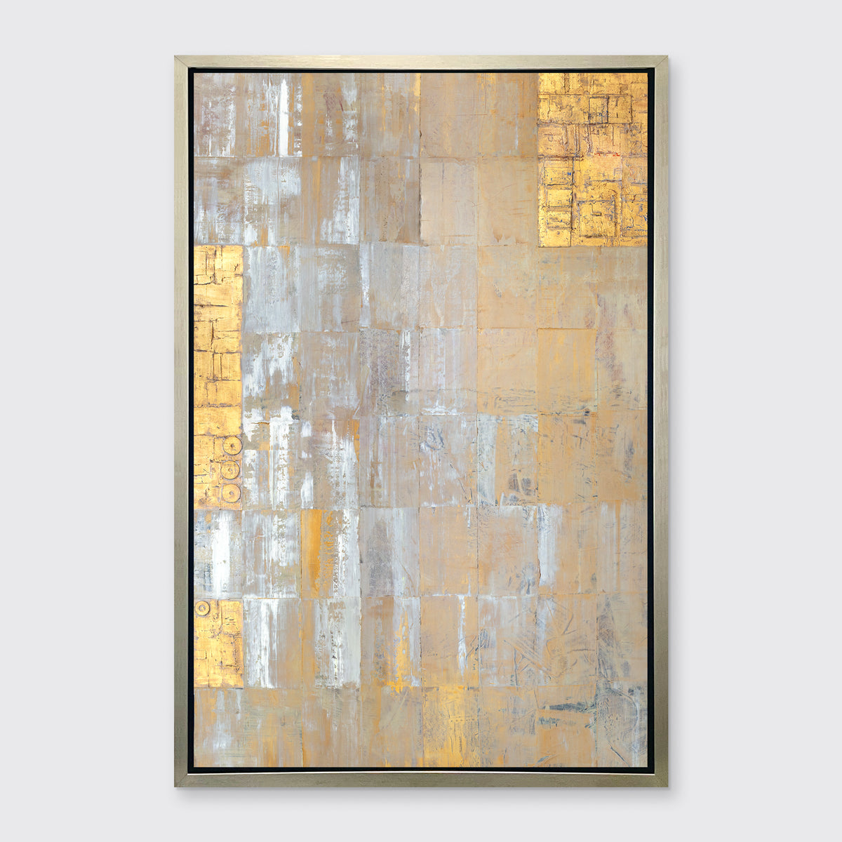 A grey, silver and gold abstract geometric print in a silver floater frame hangs on a white wall.