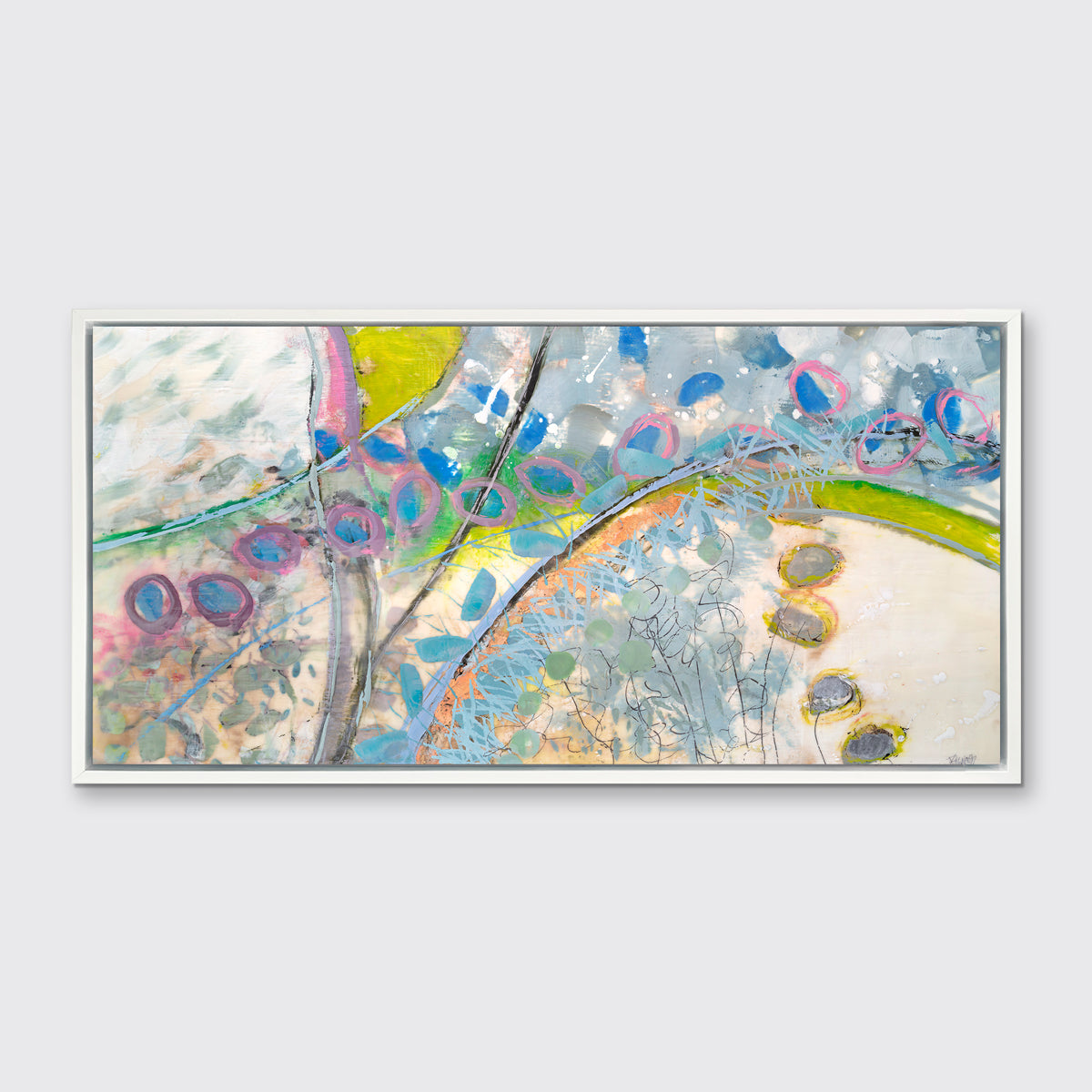 A multicolored abstract print in a white floater frame hangs on a white wall.