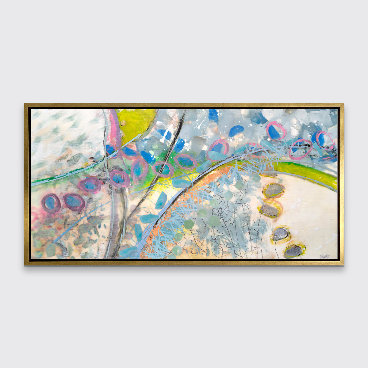 A multicolored abstract print in a gold floater frame hangs on a white wall.