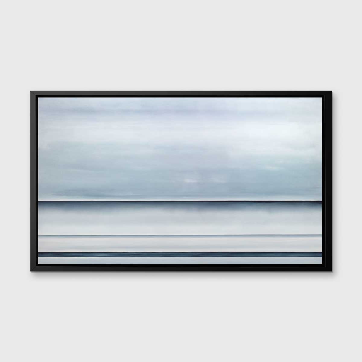 A tonal blue abstract landscape print in a black floater frame hangs on a white wall.