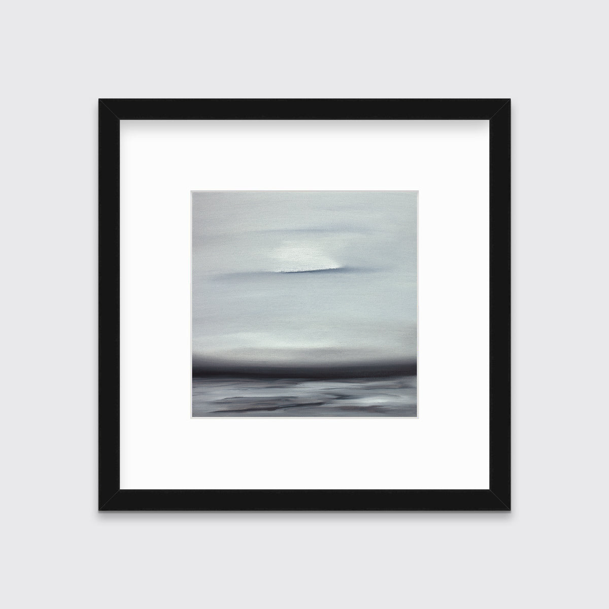 A tonal grey and black print in a black frame with a mat hangs on a white wall.