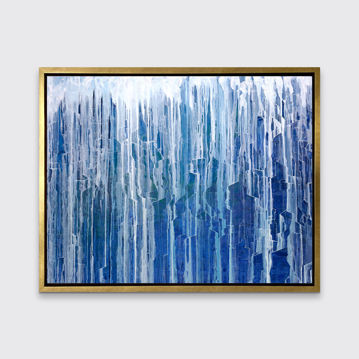 A blue and white abstract print in a gold floater frame hangs on a white wall.
