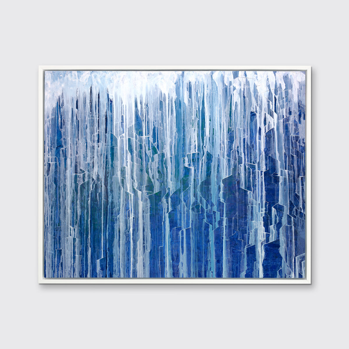 A blue and white abstract print in a white floater frame hangs on a white wall.