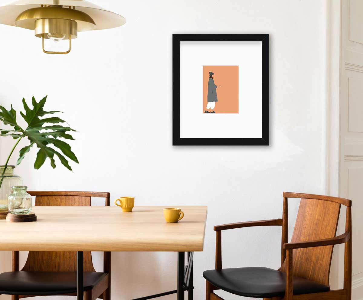 Art print of an illustrated woman wearing grey hat and coat, white pants, and grey sneakers, holding a cigarette with orange background, framed in a black frame above a modern wooden table and two chairs.
