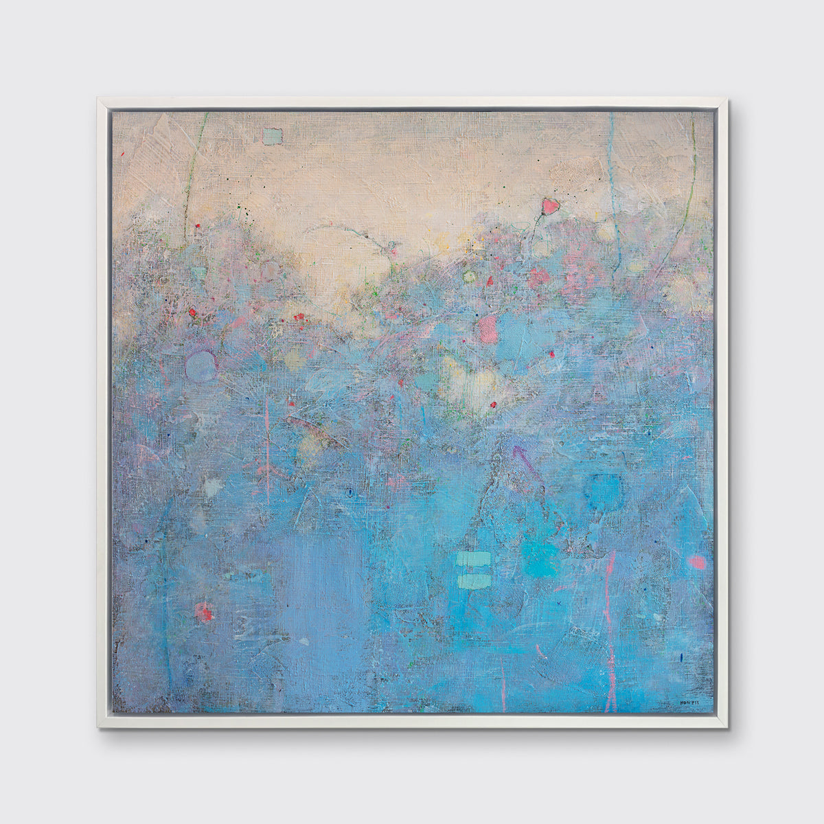 A blue abstract landscape in a white floater frame hangs on a white wall.