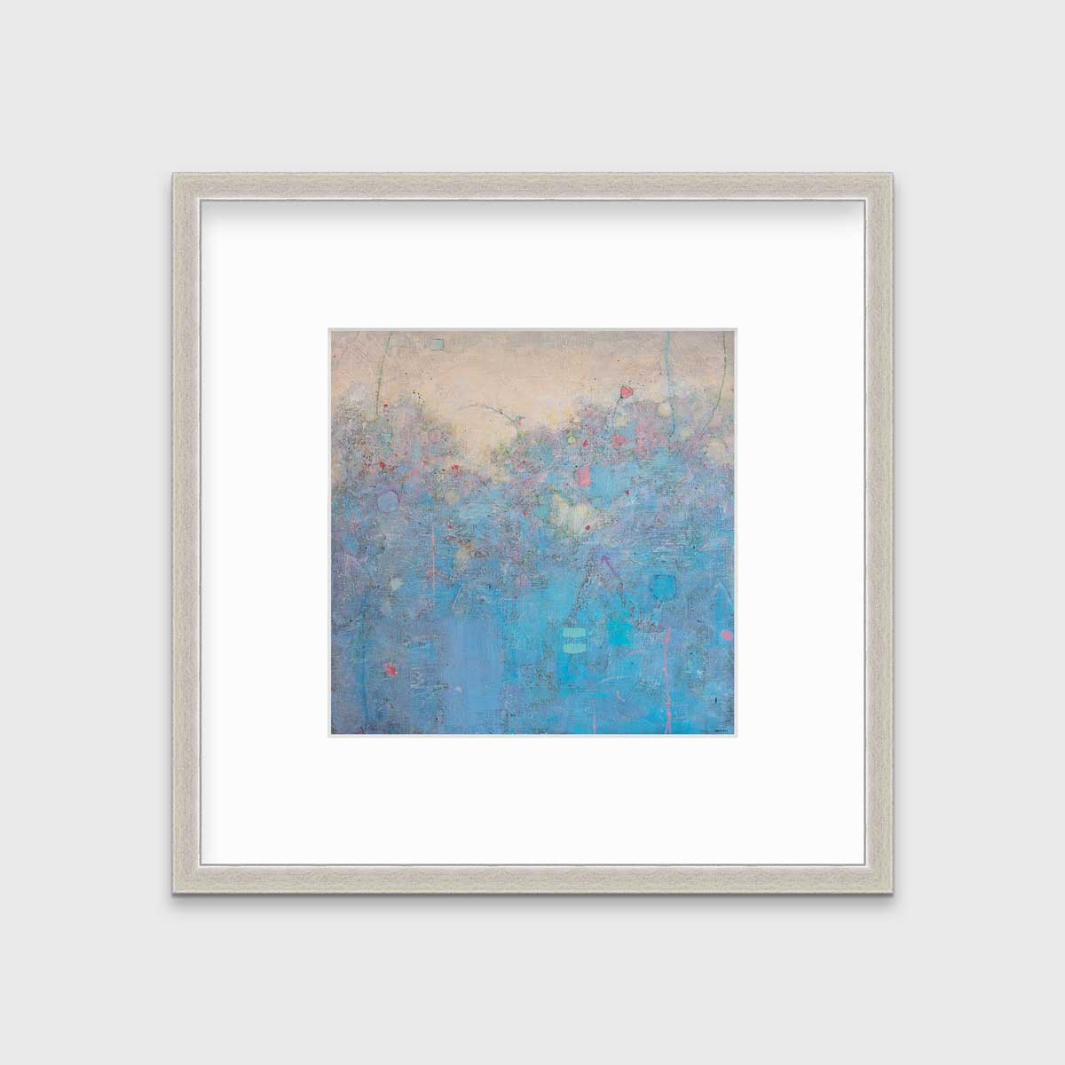 A blue abstract landscape print in a silver frame with a mat hangs on a white wall.