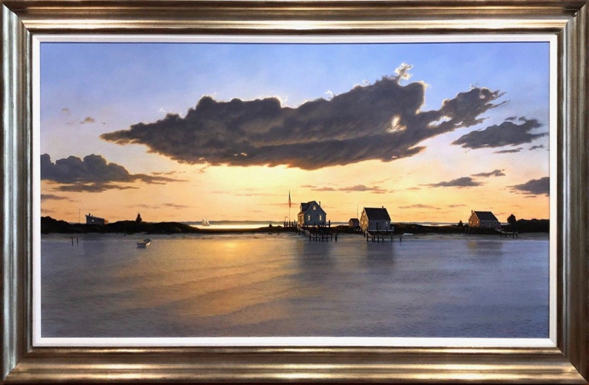 A contemporary realist painting of peninsula at sunset. The sea is calm off in the horizon you can see some sailboats still out. There are three small houses perched on the small srip of land each house with it's own dock. The sun is on it's way down and hidden by a large dense cloud, but still managing to cast a stream of golden light on the sea.