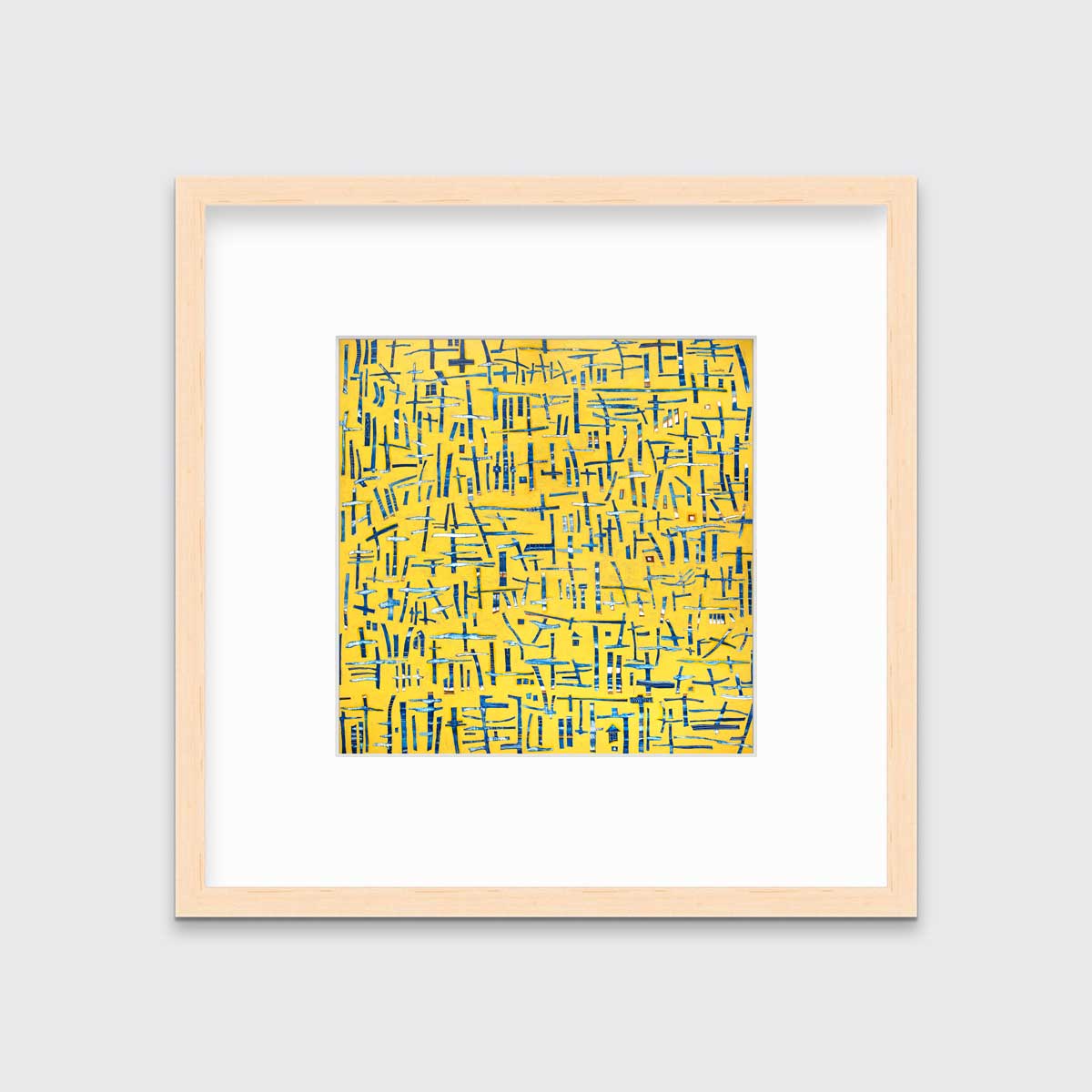 A yellow, blue and white abstract print in a natural wood frame with a mat hangs on a white wall.