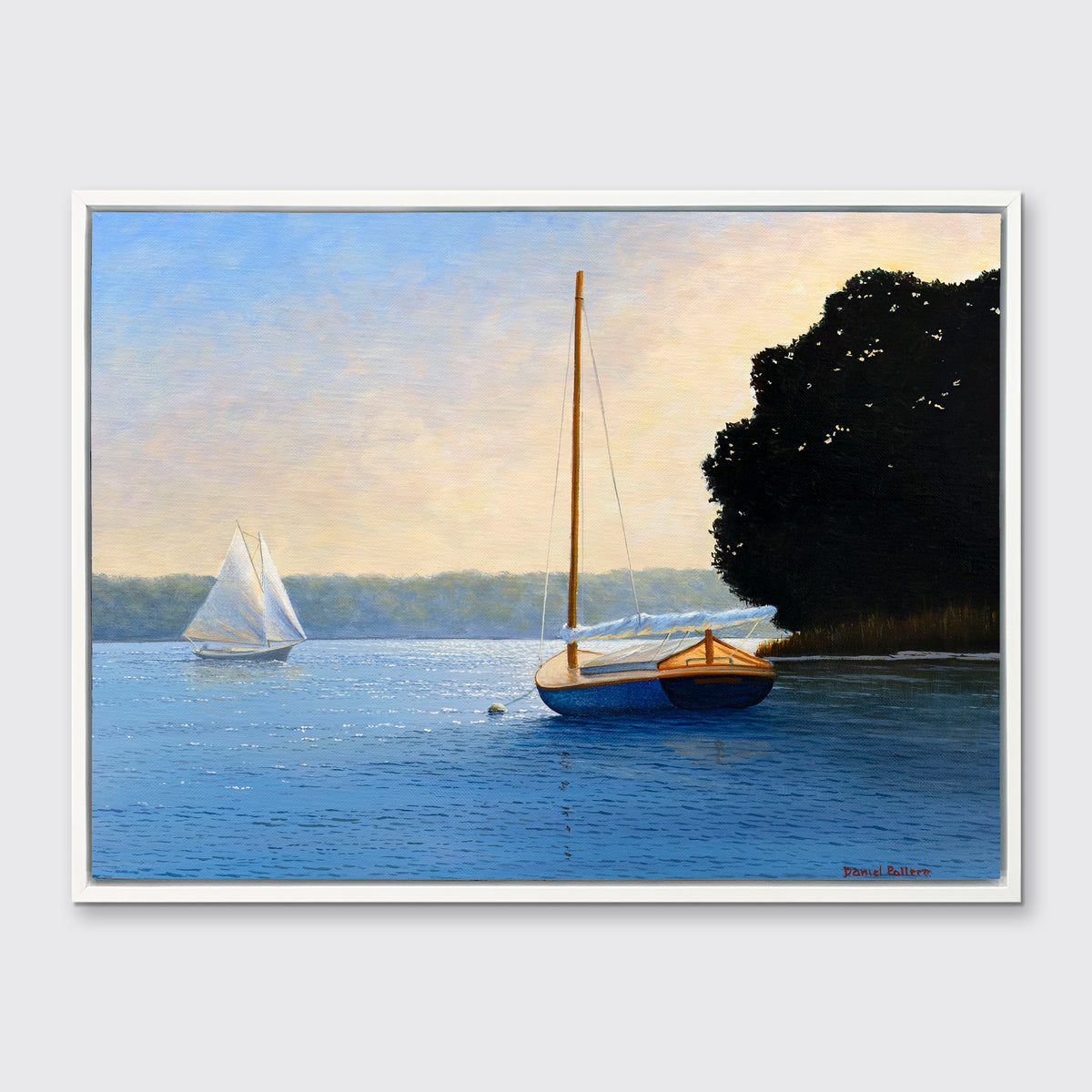 A blue, beige and black contemporary seascape print with two sailboats in a white floater frame hangs on a white wall.