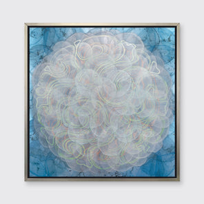 A blue, white, orange and yellow abstract geometric print in a silver floater frame hangs on a white wall.