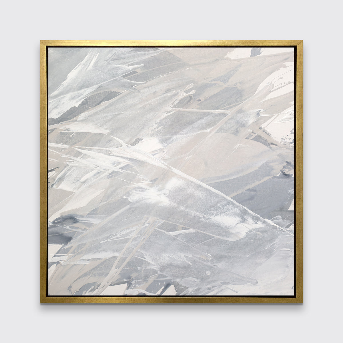 A grey, beige and white abstract print in a gold floater frame hangs on a white wall.